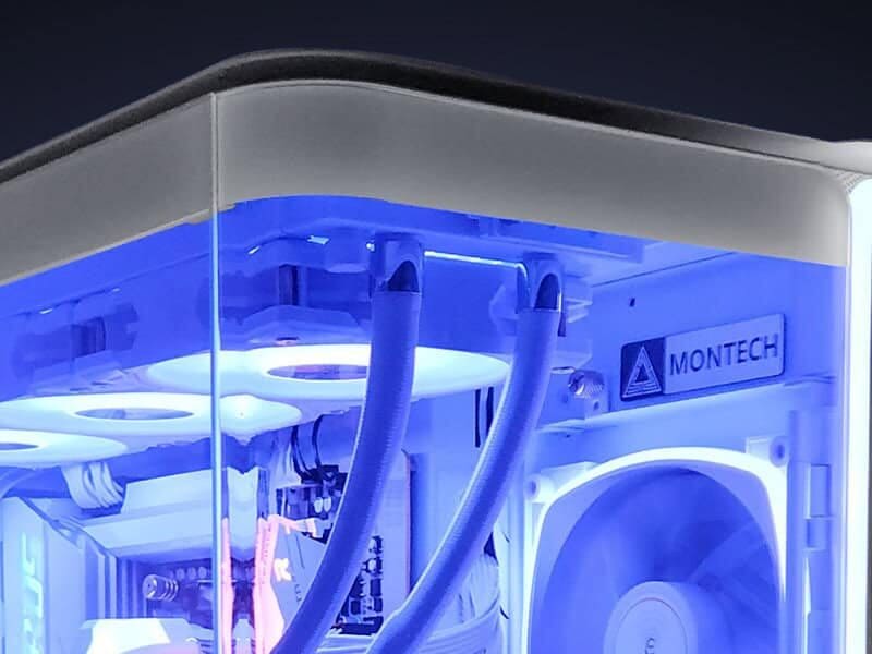 Close view of sleeved cooling tubes and tidy routing at the top of a white gaming PC